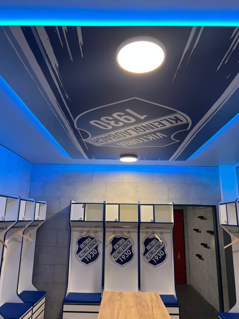 Decke der neuen Heimkabine mit großem Vereinswappen und blauer LED-Beleuchtung