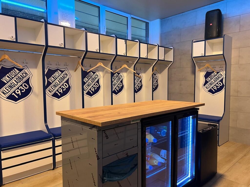 Neue Heimkabine mit Wappen-Spinden, Holztisch und beleuchtetem Getränkekühlschrank