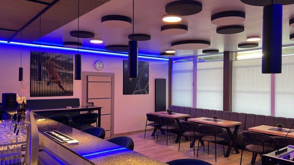 Gastraum im neuen Vereinsheim mit Theke, Sitzgruppen, Polsterbank und blauer LED-Beleuchtung