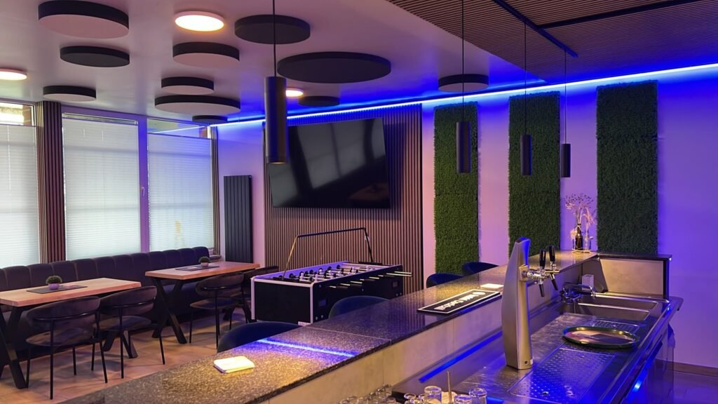 Blick über die Theke auf Sitzgruppen, Kicker und Fernseher im neuen Vereinsheim